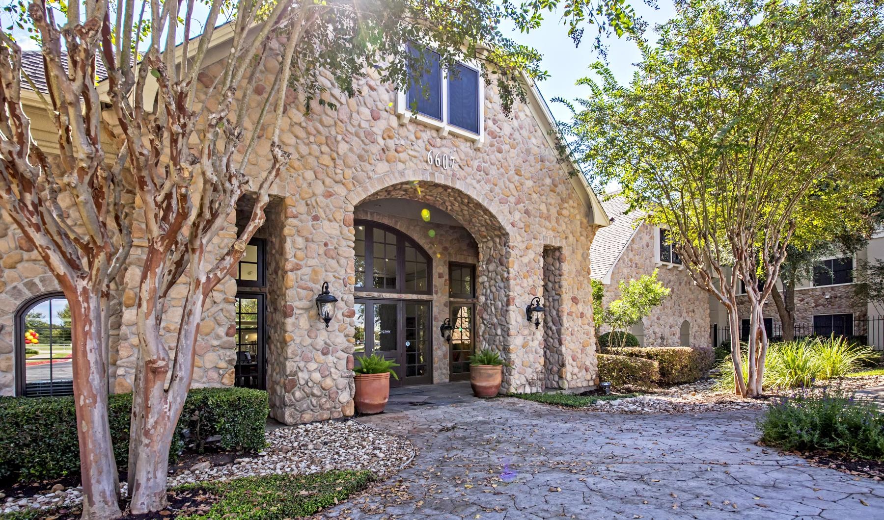 a stone building with a stone driveway